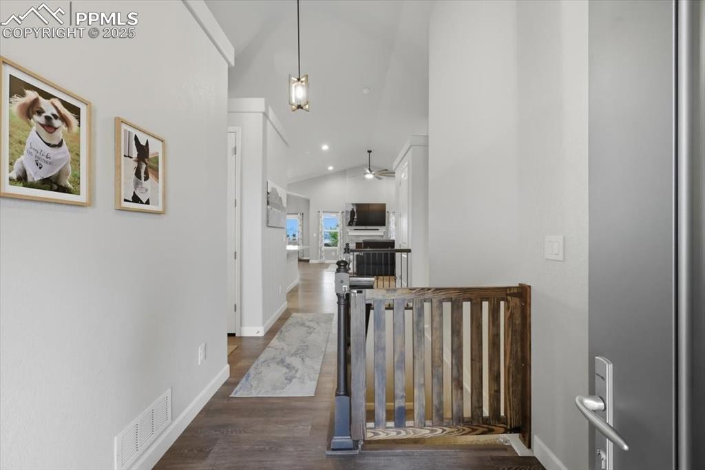 Image 3 of 47: Corridor with dark wood-style flooring, an upstairs landing, high vaulted c
