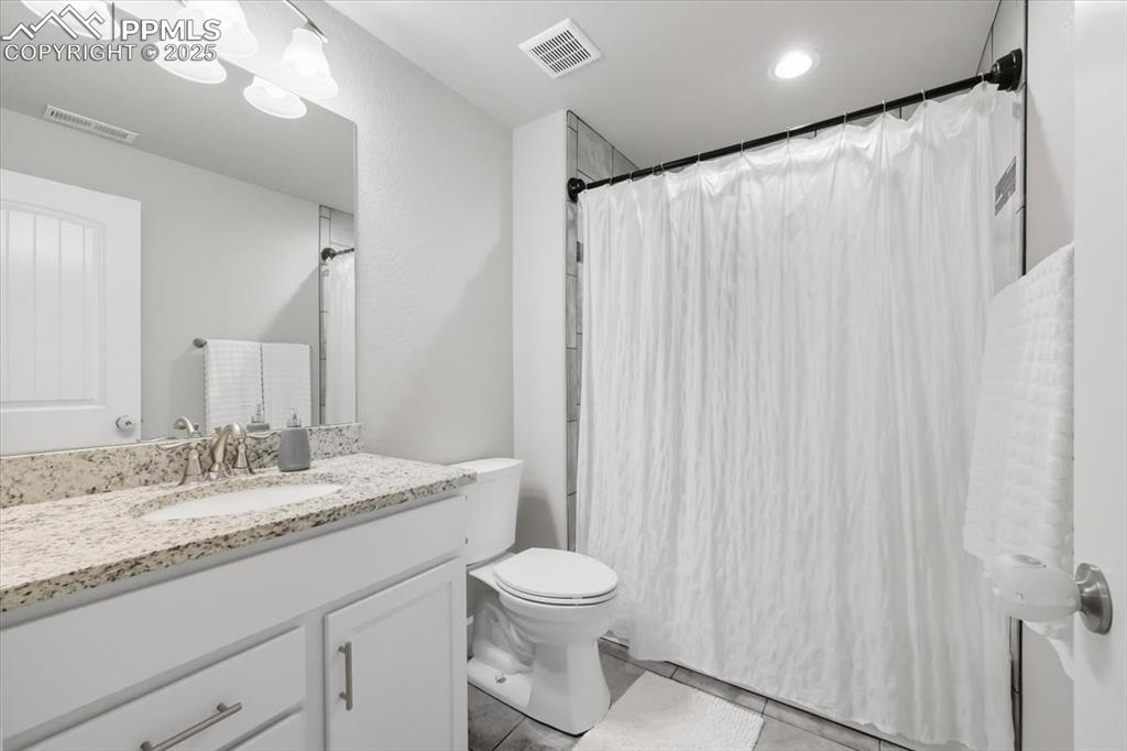 Image 35 of 47: Downstairs Full Bathroom with vanity, light tile patterned floors, and a sh