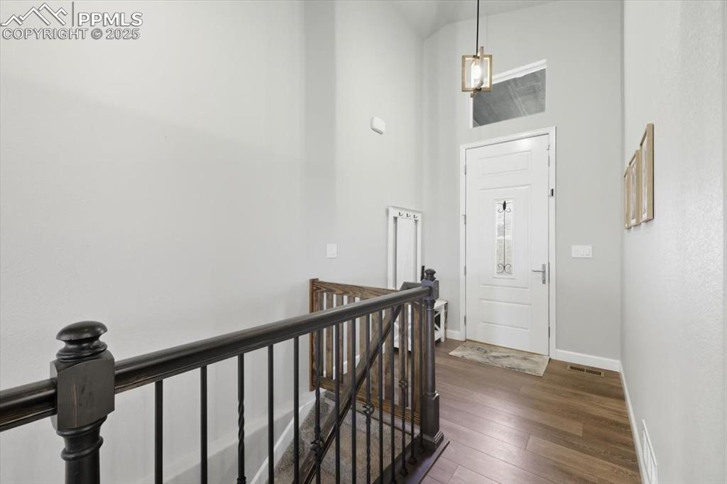 Image 4 of 47: Foyer featuring dark wood-style floors and a high ceiling
