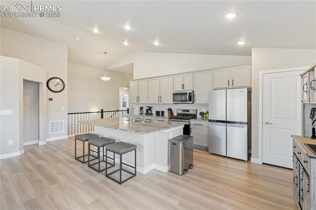 Image 17 of 46: Kitchen featuring appliances with stainless steel finishes, an island with 