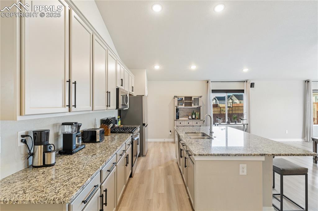 Image 20 of 46: Kitchen featuring light wood-type flooring, recessed lighting, light stone 