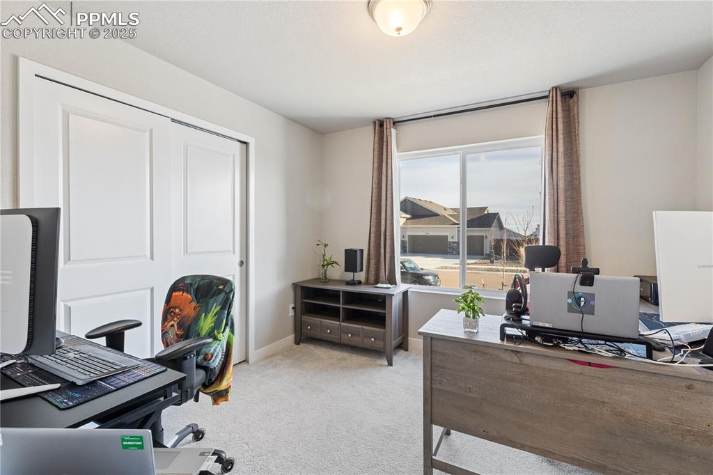 Image 24 of 46: Office space with light colored carpet and baseboards