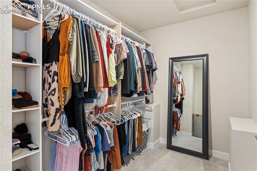Image 27 of 46: Walk in closet featuring light colored carpet and attic access