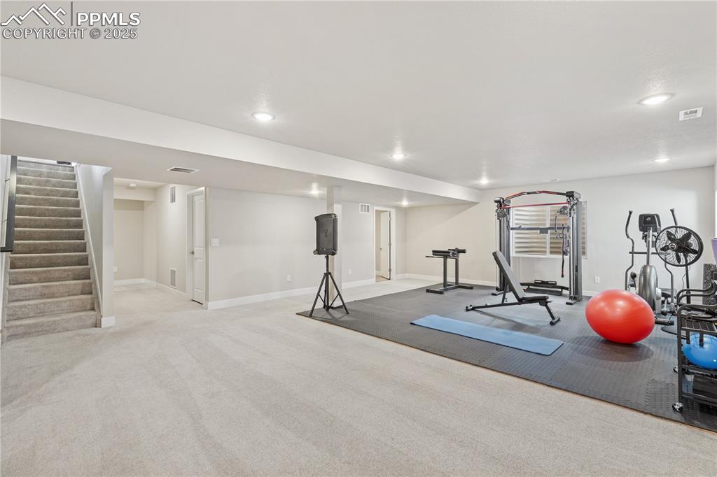 Image 33 of 46: Exercise room with light colored carpet and recessed lighting