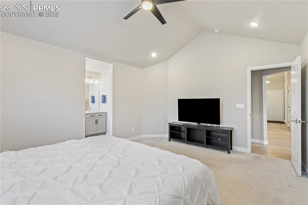 Image 9 of 46: Bedroom with light colored carpet, lofted ceiling, ceiling fan, recessed li