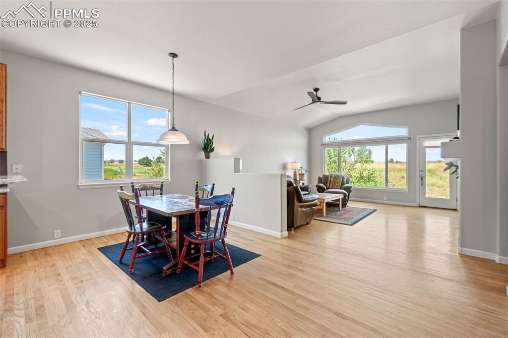 Image 12 of 39: Dining area featuring light wood-style flooring, vaulted ceiling, and a cei