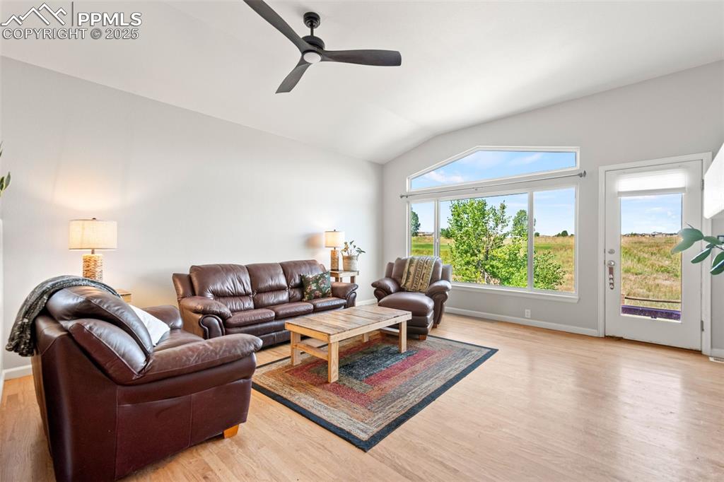 Image 15 of 39: Living room with lofted ceiling, light wood-style floors, and ceiling fan