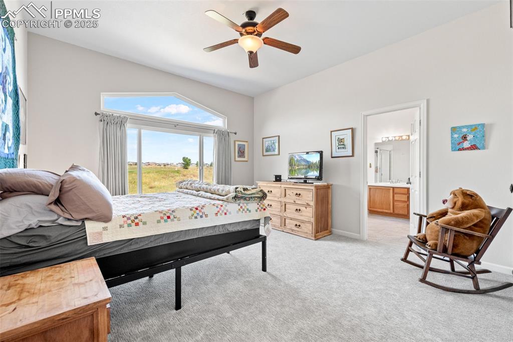 Image 18 of 39: Bedroom featuring light carpet, a ceiling fan, and ensuite bath