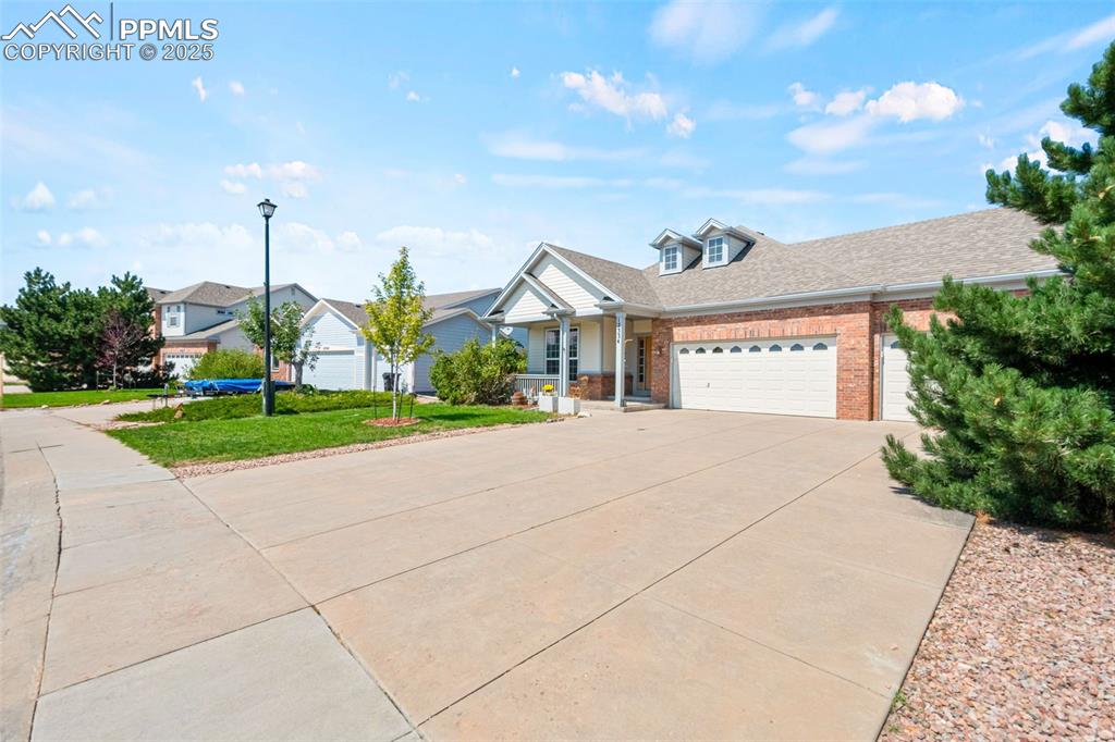 Image 3 of 39: View of front of home with driveway, a garage, brick siding, a shingled roo