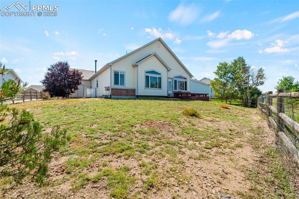 Image 34 of 39: Rear view of property featuring a fenced backyard and brick siding