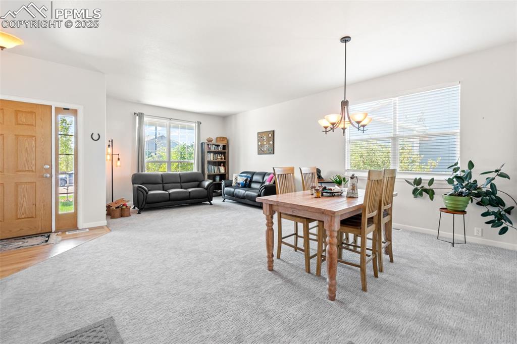 Image 7 of 39: Dining space featuring light carpet and a chandelier