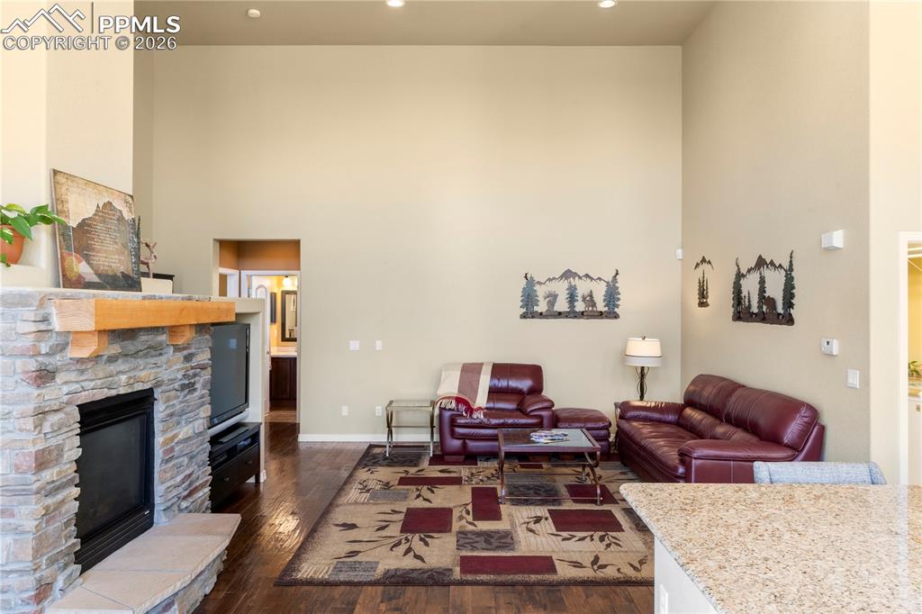 Image 12 of 43: Living room with gas fireplace and stacked stone surround. 
