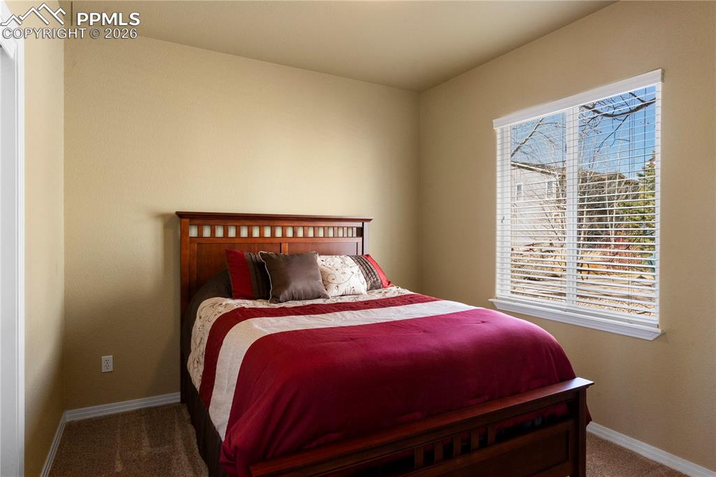 Image 17 of 43: Main level guest bedroom with carpet. 