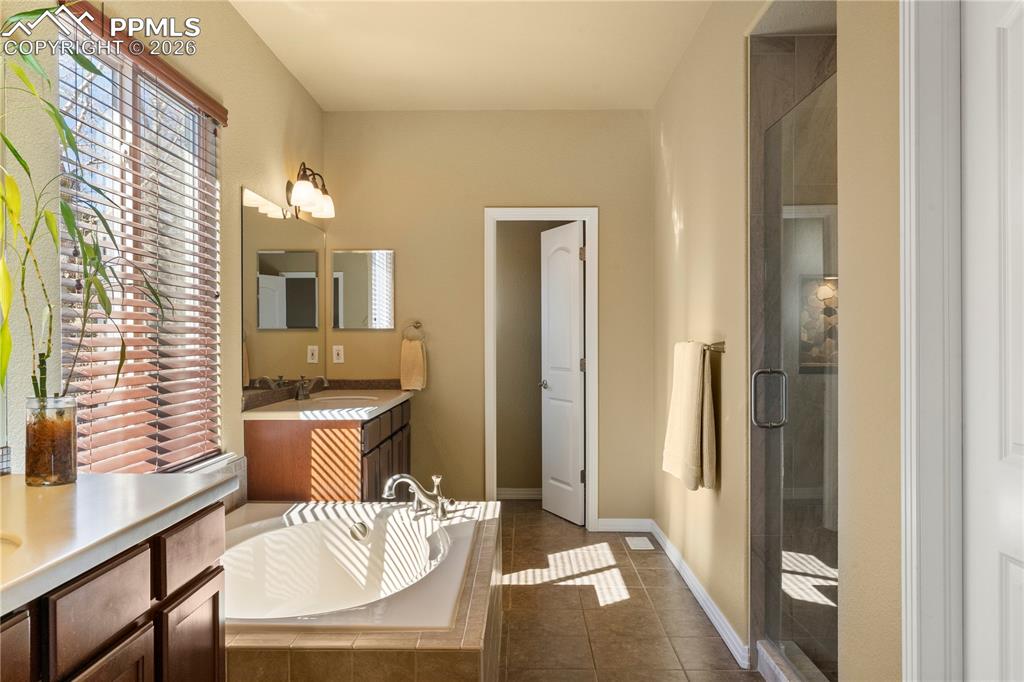 Image 21 of 43: 5 piece primary bath. Soaking tub, walk in shower and separate vanities. 