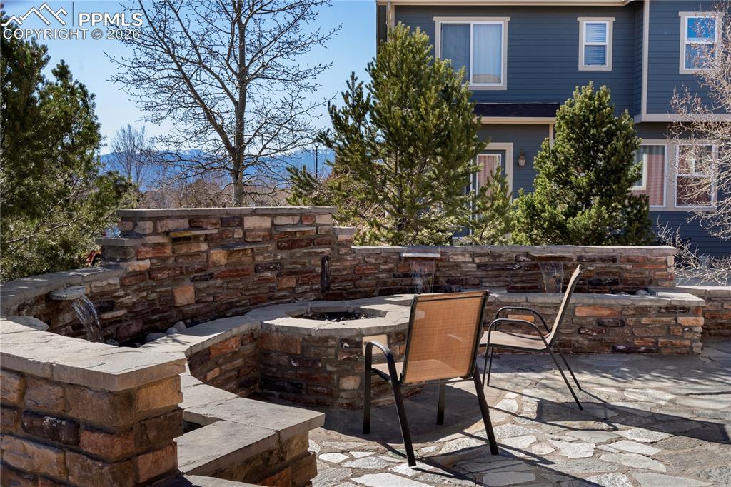Image 33 of 43: Gorgeous back patio with firepit, water feature and stunning mountain views