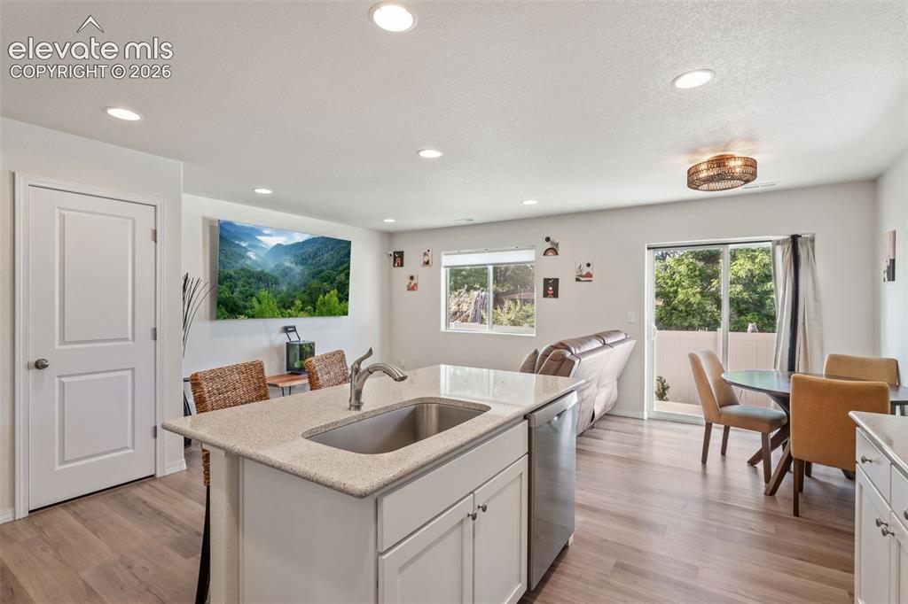 Image 15 of 38: Open-concept living space featuring wood-finish flooring, recessed lighting