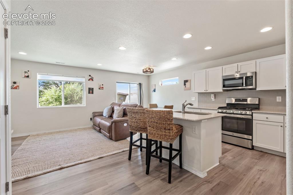 Image 2 of 38: Open-concept living space featuring wood-finish flooring throughout