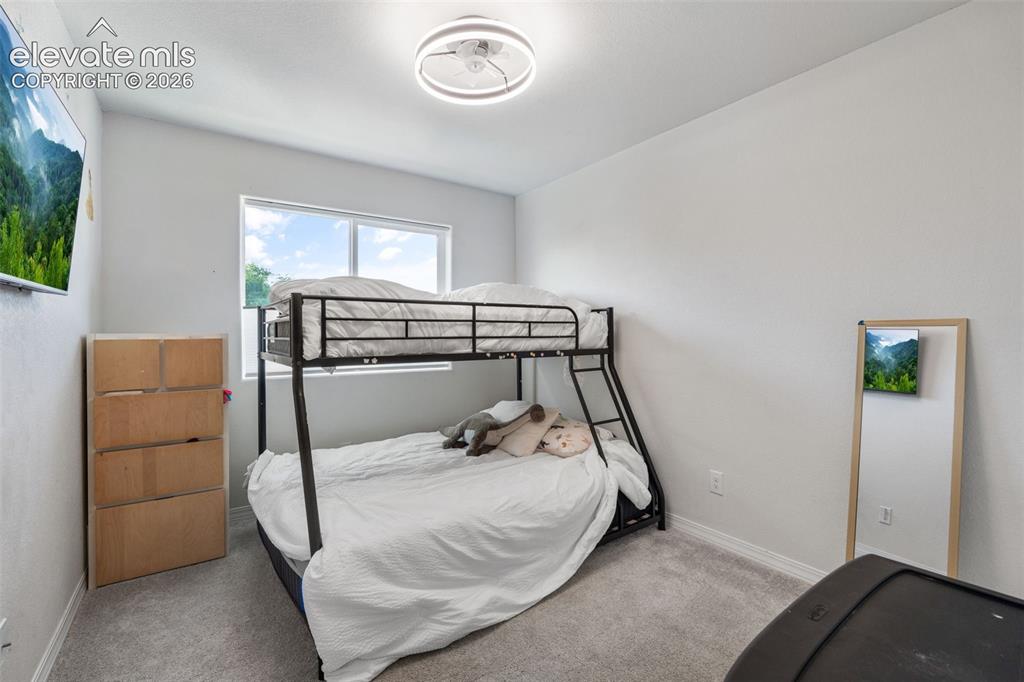 Image 22 of 38: Bright room with light gray walls, plush gray carpeting, and a modern ceili