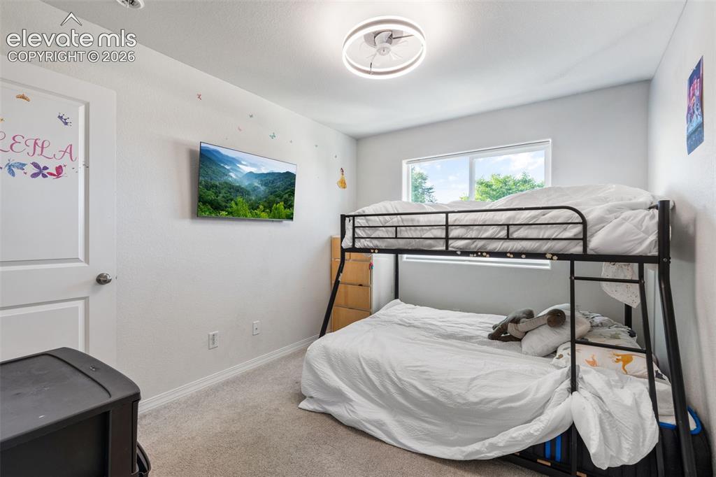 Image 23 of 38: Bedroom featuring light gray walls, plush carpet flooring, a modern flush-m