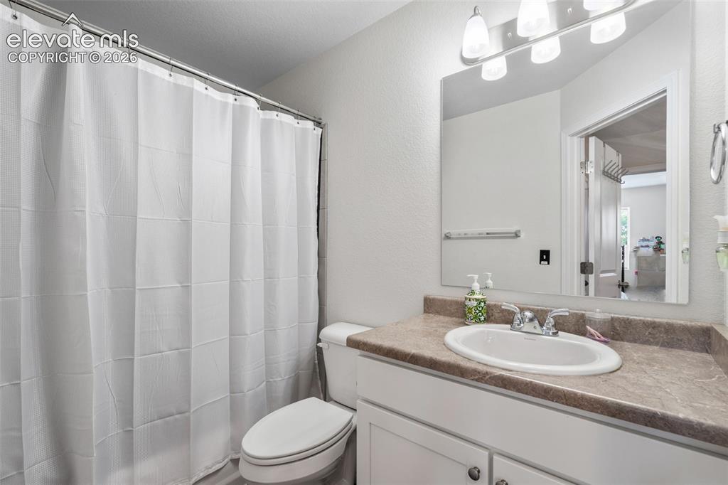 Image 25 of 38: Bathroom featuring a vanity with a laminate countertop, an undermount sink,
