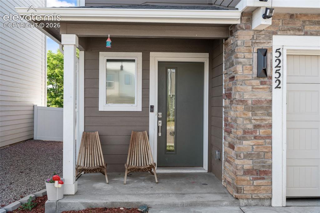 Image 5 of 38: Inviting entryway featuring a dark gray door with a vertical glass insert, 