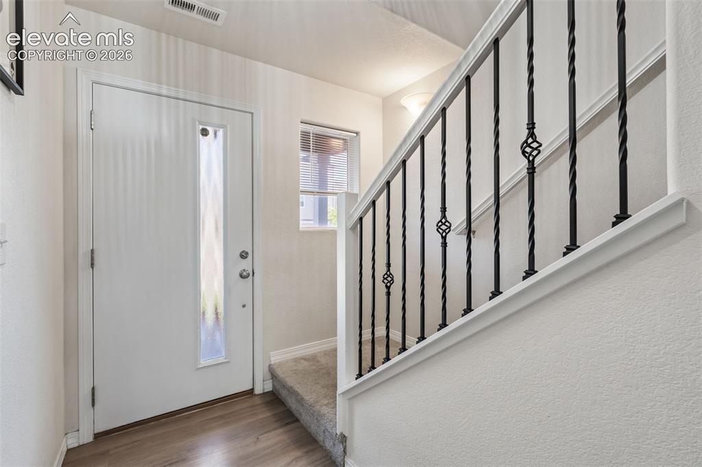 Image 7 of 38: Entryway featuring a white door with a full-length frosted glass insert, wo