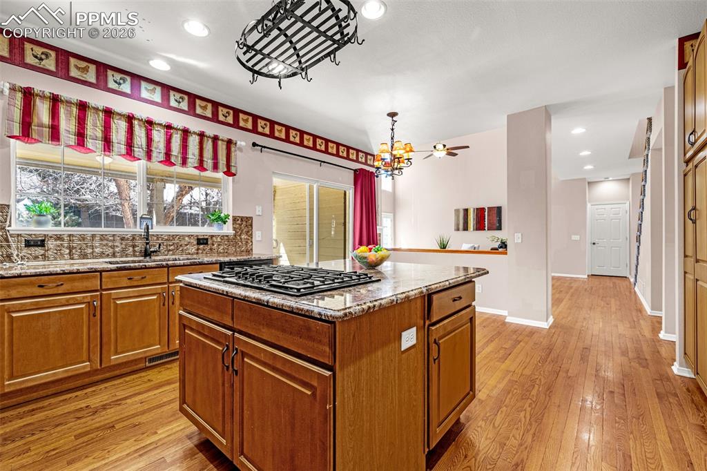 Image 7 of 39: Large island features gas top range and plenty of storage below