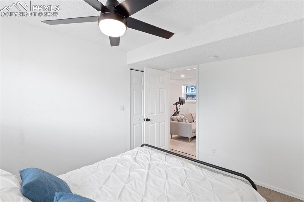 Image 19 of 24: Downstairs bedroom with carpet, a closet, and ceiling fan
