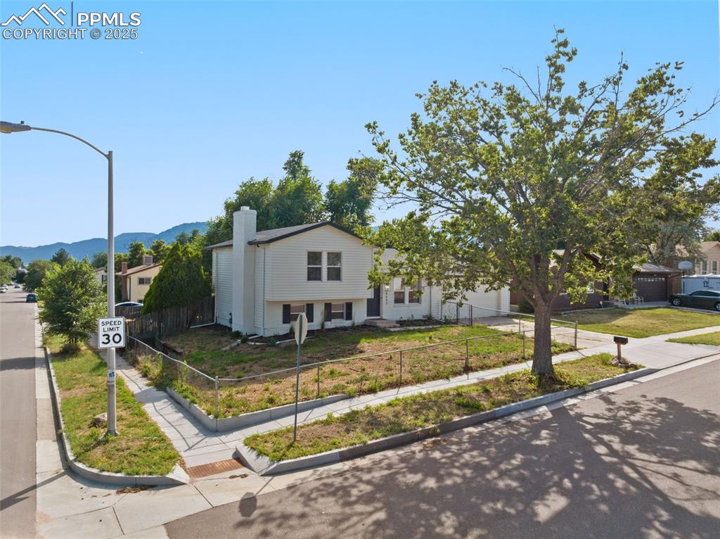Image 2 of 24: View of front of home featuring a chimney, driveway, a mountain view, and a