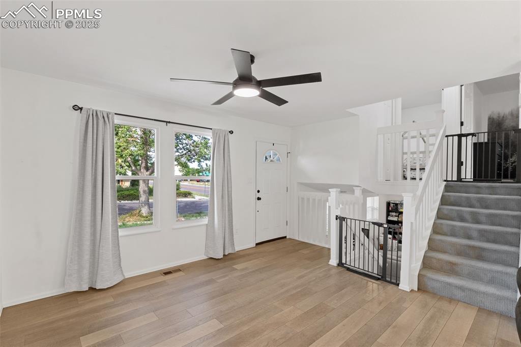 Image 4 of 24: Entrance foyer with LVP flooring and open concept living. Gates are removab
