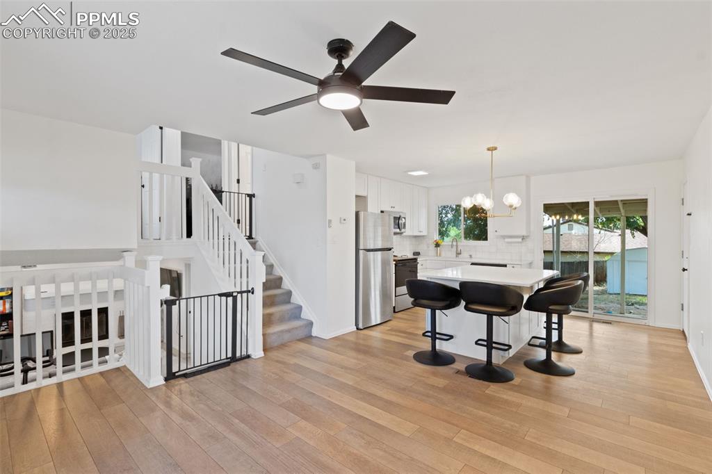 Image 5 of 24: Kitchen with stainless steel appliances, quartz countertops, ceiling fan, w