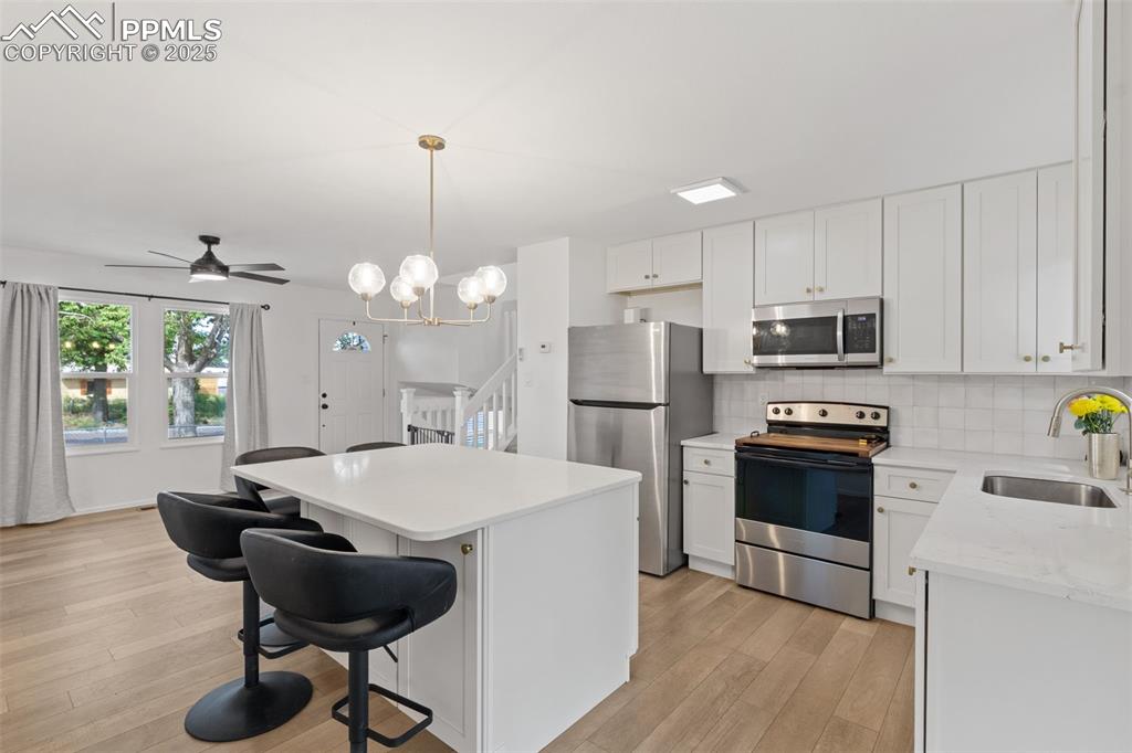 Image 6 of 24: Kitchen hosting appliances with stainless steel finishes, LVP floors, a kit