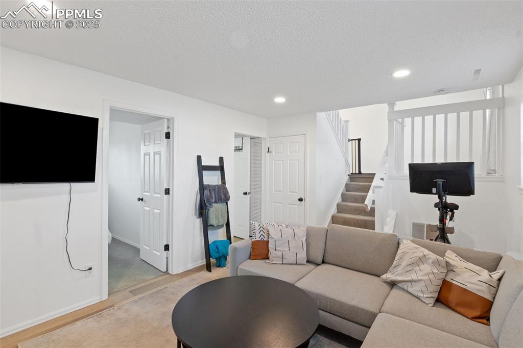 Image 9 of 24: Family room featuring stairway, recessed lighting, LVP flooring, and a text