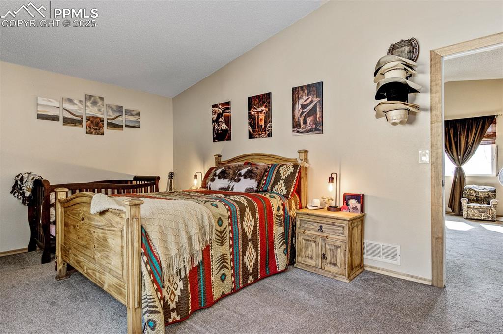 Image 10 of 27: Bedroom featuring carpet and lofted ceiling