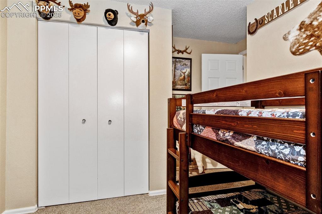 Image 18 of 27: Bedroom with carpet flooring and a textured ceiling