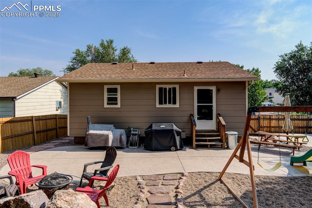 Image 24 of 27: Rear view of property with entry steps, an outdoor fire pit, a patio, and a