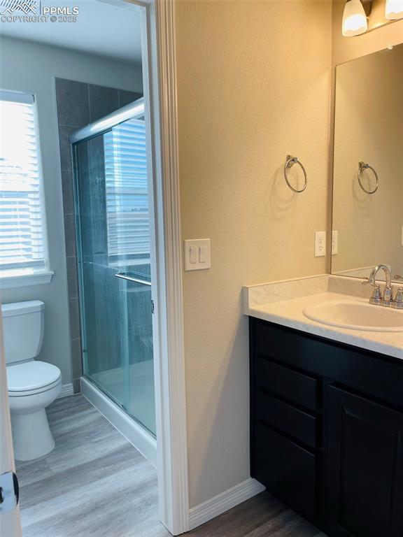 Image 11 of 19: Bathroom featuring vanity, a shower stall, and dark wood-style floors