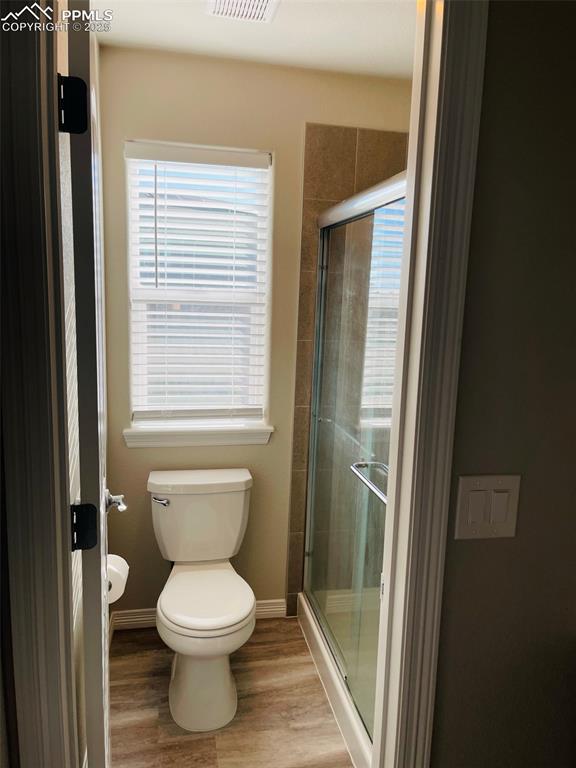 Image 12 of 19: Full bath with a stall shower and light wood finished floors