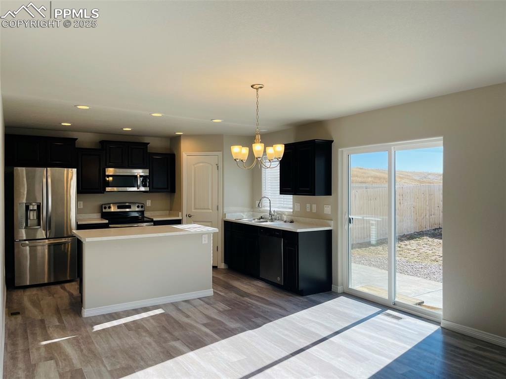 Image 2 of 19: Kitchen featuring dark cabinets, stainless steel appliances, light countert