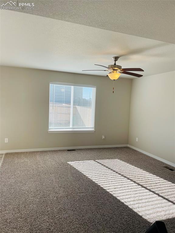 Image 3 of 19: Carpeted empty room with a textured ceiling and ceiling fan