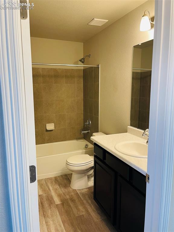 Image 7 of 19: Bathroom featuring shower / tub combination, vanity, and light wood-style f