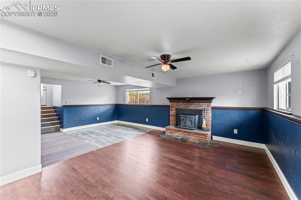 Image 26 of 40: Lower level living room with wood fireplace