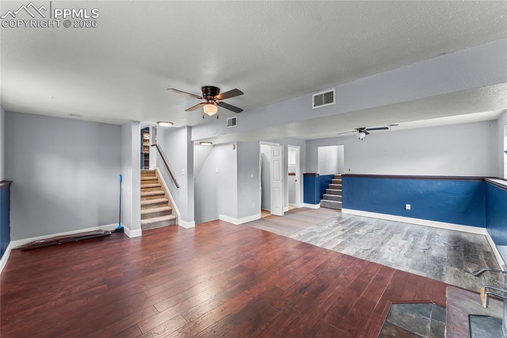 Image 27 of 40: Lower level living room with wood fireplace
