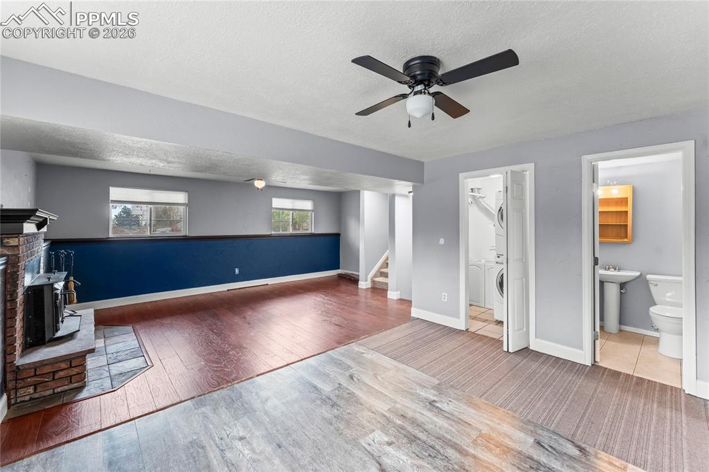 Image 28 of 40: Lower level living room with laundry and half bathroom