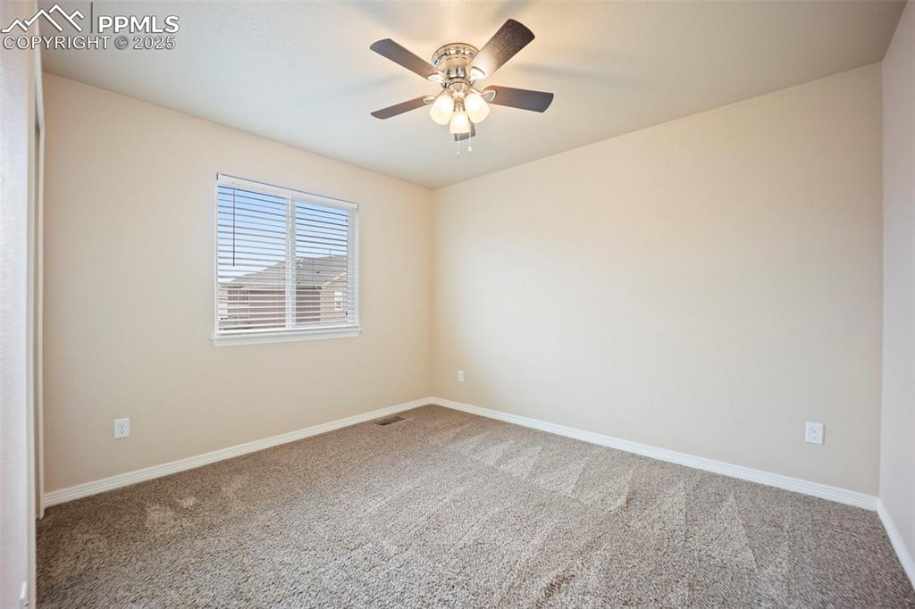 Image 16 of 39: Empty room with carpet flooring and a ceiling fan