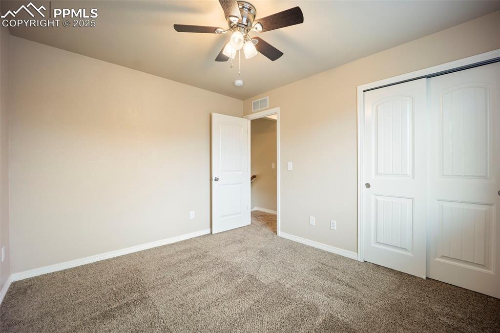 Image 18 of 39: Unfurnished bedroom with carpet, a closet, and a ceiling fan