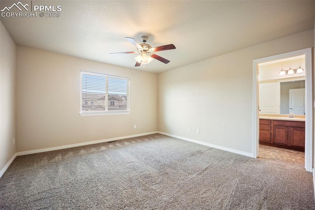 Image 19 of 39: Unfurnished bedroom with light colored carpet, connected bathroom, and a ce