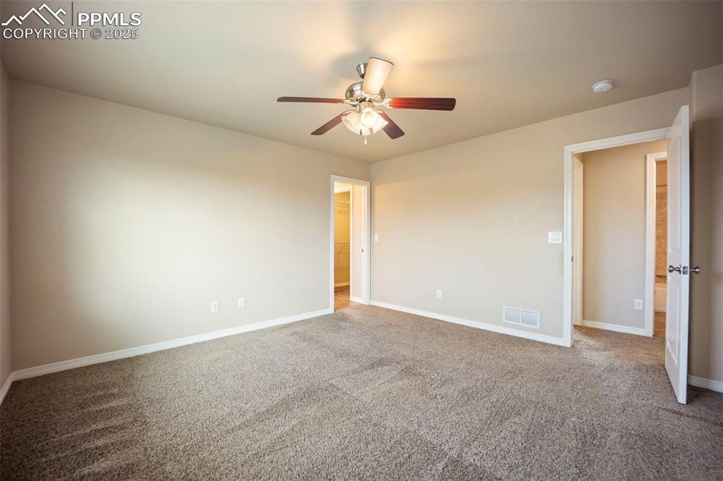 Image 20 of 39: Unfurnished bedroom with carpet flooring, ceiling fan, and a walk in closet