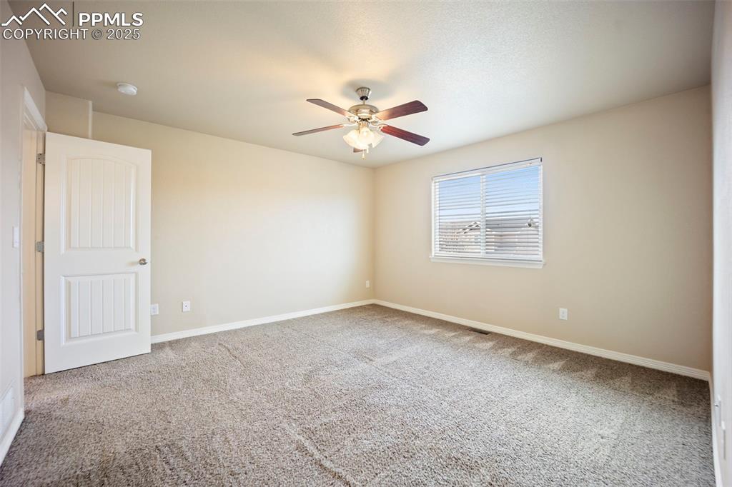 Image 21 of 39: Carpeted spare room featuring baseboards and a ceiling fan