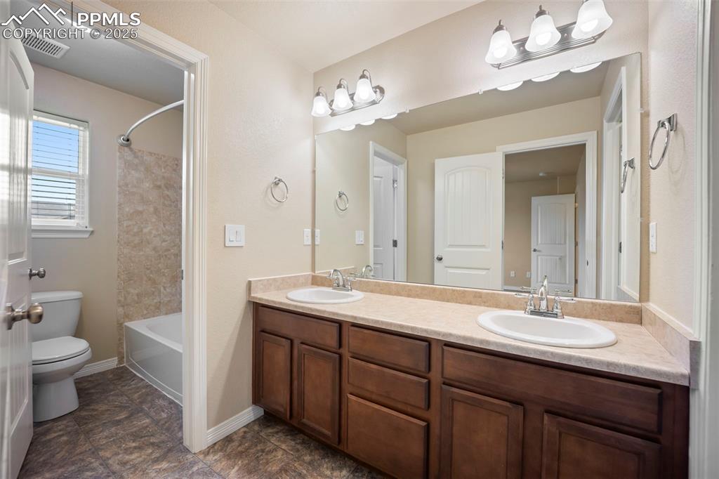 Image 22 of 39: Full bath with double vanity and shower / bath combo